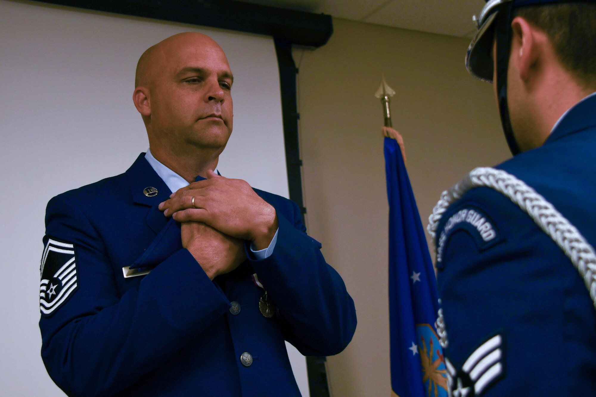 U.S. Air Force Senior Master Sgt. Wendell Weeks, 307th Security Forces Squadron training manager, holds an American flag to his chest during his retirement ceremony at Barksdale Air Force Base, La., March 4, 2017. During his 26-year career, Weeks served in several different capacities in the 307th Bomb Wing including communications, security forces and as 707th Maintenance Squadron first sergeant. (U.S. Air Force photo by Tech. Sgt. Ted Daigle/Released)