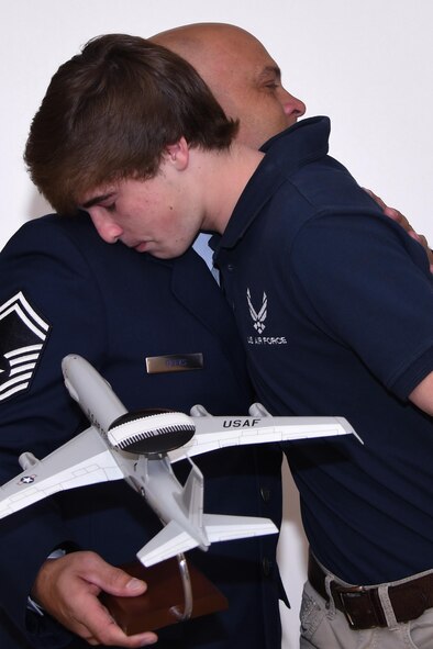 U.S. Air Force Senior Master Sgt. Wendell Weeks, 307th Security Forces Squadron training manager, hugs his son, Christian, after presenting him with a replica of an E-3 Sentry at Barksdale Air Force Base, La., March 4, 2017.  Weeks made the presentation during his retirement ceremony in honor of his oldest son, Kyle, who had been a crew member on the jet.  Kyle was killed in a traffic accident last year after separating from active duty.  (U.S. Air Force photo by Tech. Sgt. Ted Daigle/Released)