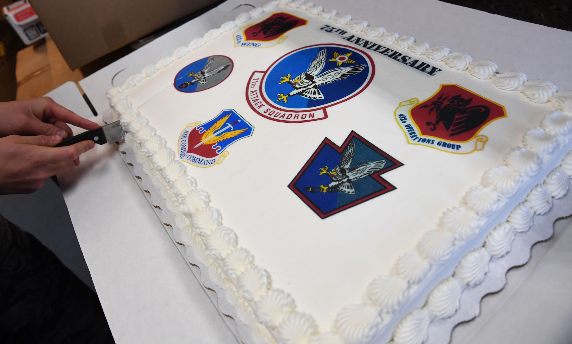 An Airman with the 11th Attack Squadron cuts into a cake March 3, 2017, at Creech Air Force Base, Nev. The 11th ATKS celebrated its 75th anniversary of providing America with key warfighting capabilities such as intelligence, surveillance and reconnaissance. (U.S. Air Force photo/Airman 1st Class James Thompson) 