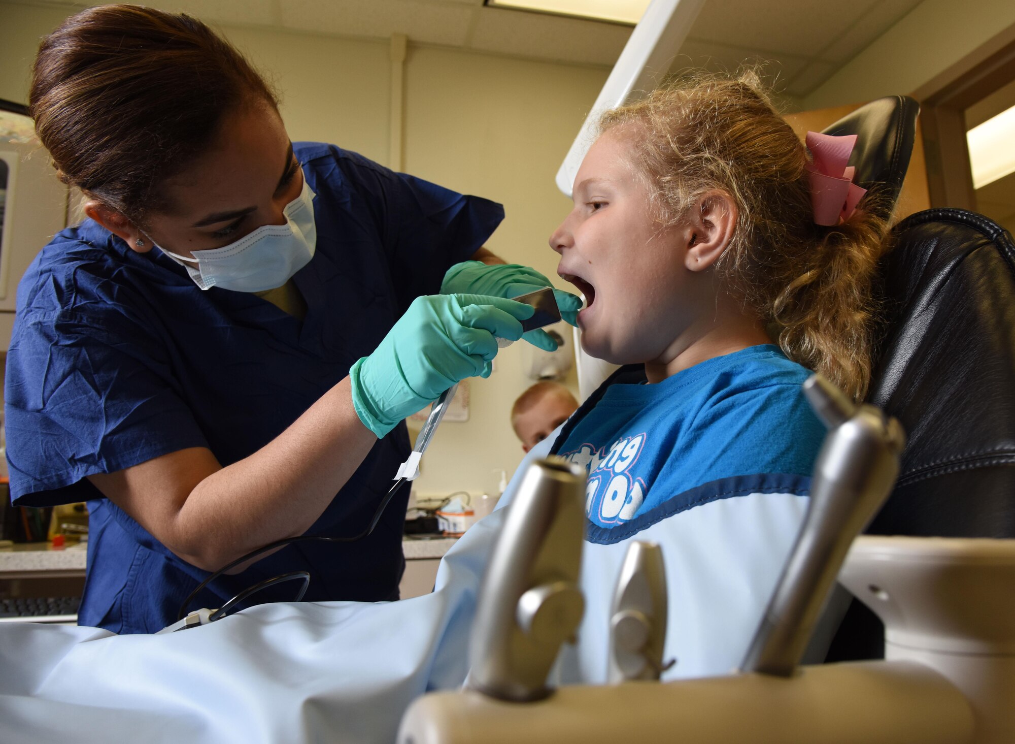 Senior Airman Caitlyn Hollowell, 81st Dental Squadron dental technician, prepares to take an x-ray on Katelyn Landolt, daughter of Lt. Col. Barbara Hoeben, 81st Diagnostic and Therapeutics Squadron clinical pharmacist, during the 7th Annual Give Kids a Smile Day at the dental clinic March 1, 2017, on Keesler Air Force Base, Miss. The event was held in recognition National Children’s Dental Health Month and included free dental exams, radiographs and cleanings for more than 95 children age 2 and older. (U.S. Air Force photo by Kemberly Groue)