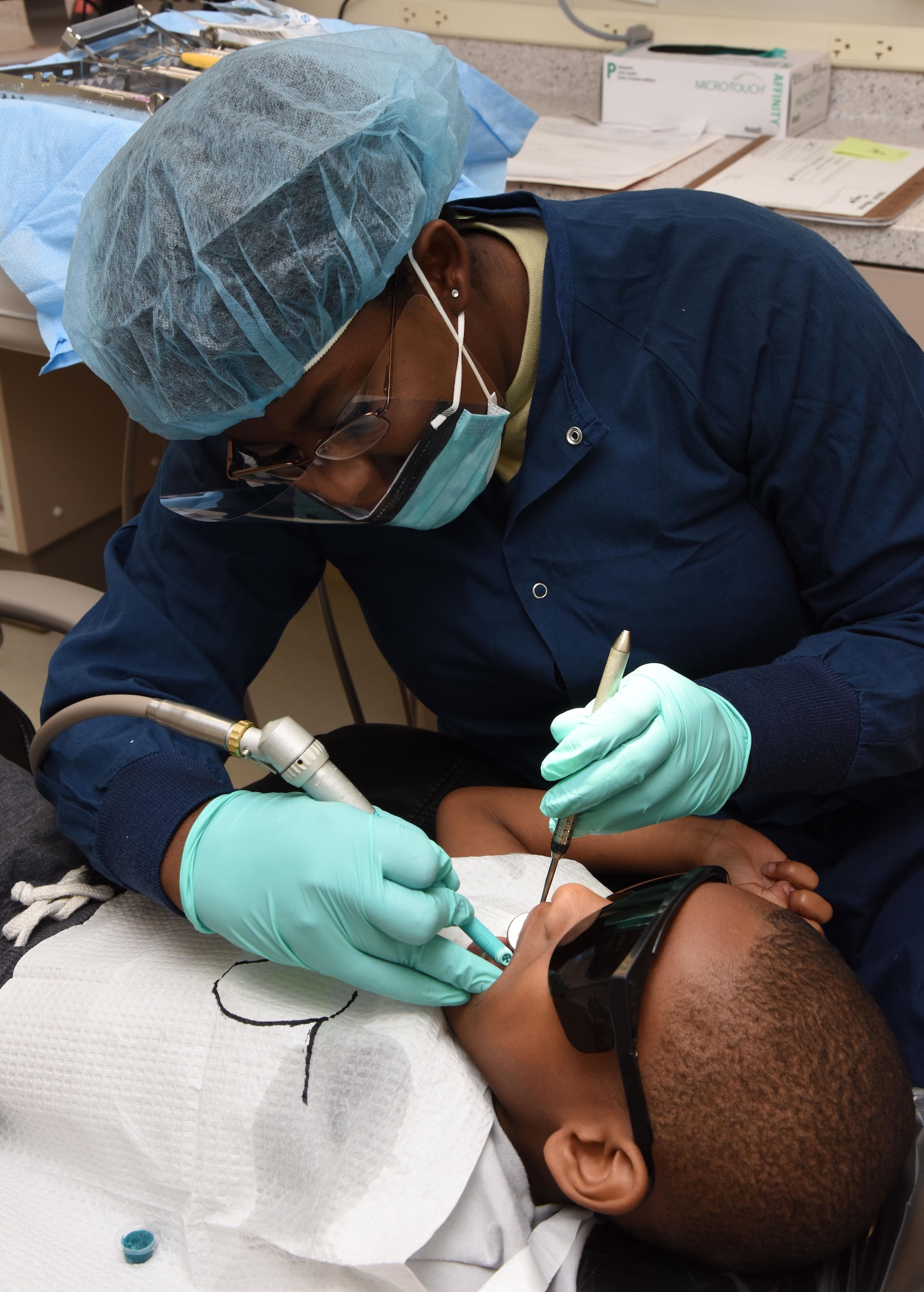 Senior Airman Ne’Sha Richard, 81st Dental Squadron dental technician, provides an oral prophylaxis on Joshua McGee, son of Staff Sgt. Eric Castleberry, 86th DS dental technician, Ramstein Air Base, Germany, during the 7th Annual Give Kids a Smile Day at the dental clinic March 1, 2017, on Keesler Air Force Base, Miss. The event was held in recognition National Children’s Dental Health Month and included free dental exams, radiographs and cleanings for more than 95 children age 2 and older. (U.S. Air Force photo by Kemberly Groue)