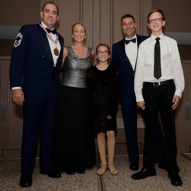 Chief Master Sgt. Miguel Clavijo, left, and his family pose with Chief Master Sgt. Tim Bianchi, 920th Rescue Wing command chief, during the annual Space Coast Chief Master Sergeant Recognition Ceremony in Cocoa Beach, Florida, on March 3, 2017. The ceremony honored Clavijo, along with 14 others, as they transitioned to the highest enlisted rank of chief master sergeant. (U.S. Air Force photo/Senior Airman Brandon Kalloo Sanes)