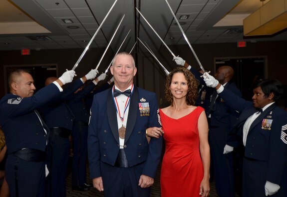 Chief Master Sgt. Dean Peterson and his wife walk through the saber gauntlet while being honored during the annual Space Coast Chief Master Sergeant Recognition Ceremony in Cocoa Beach, Florida, March 3, 2017. Peterson is the 920th Aircraft Maintenance Squadron superintendent. He, along with 14 others, were recognized for their transition to the highest enlisted rank of chief master sergeant. (U.S. Air Force photo/Senior Airman Brandon Kalloo Sanes)