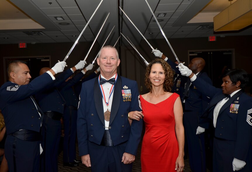 Chief Master Sgt. Dean Peterson and his wife walk through the saber gauntlet while being honored during the annual Space Coast Chief Master Sergeant Recognition Ceremony in Cocoa Beach, Florida, March 3, 2017. Peterson is the 920th Aircraft Maintenance Squadron superintendent. He, along with 14 others, were recognized for their transition to the highest enlisted rank of chief master sergeant. (U.S. Air Force photo/Senior Airman Brandon Kalloo Sanes)