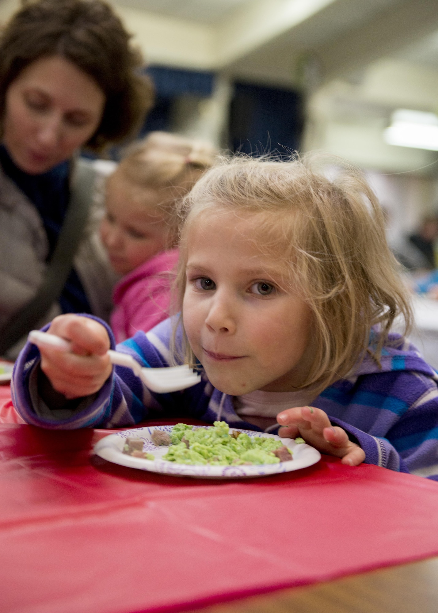 A girl tries “Green Eggs and Ham” for the first time at West Elementary School during a National Read Across America Day event, Mar. 2, 2017, at Yokota Air Base, Japan. The event had various activities for families including: oobleck (slime) making, face painting, cake decorating, green eggs and ham, a photo booth and more Dr. Seuss themed activities. (U.S. Air Force photo by Airman 1st Class Donald Hudson)