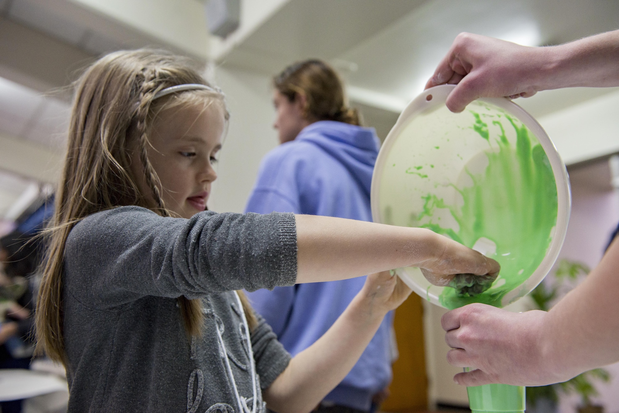 A girl makes, “oobleck,” for the first time at West Elementary School during a National Read Across America Day event, Mar. 2, 2017, at Yokota Air Base, Japan. The event had various activities for families including: oobleck (slime) making, face painting, cake decorating, green eggs and ham, a photo booth and more Dr. Seuss themed activities. (U.S. Air Force photo by Airman 1st Class Donald Hudson)