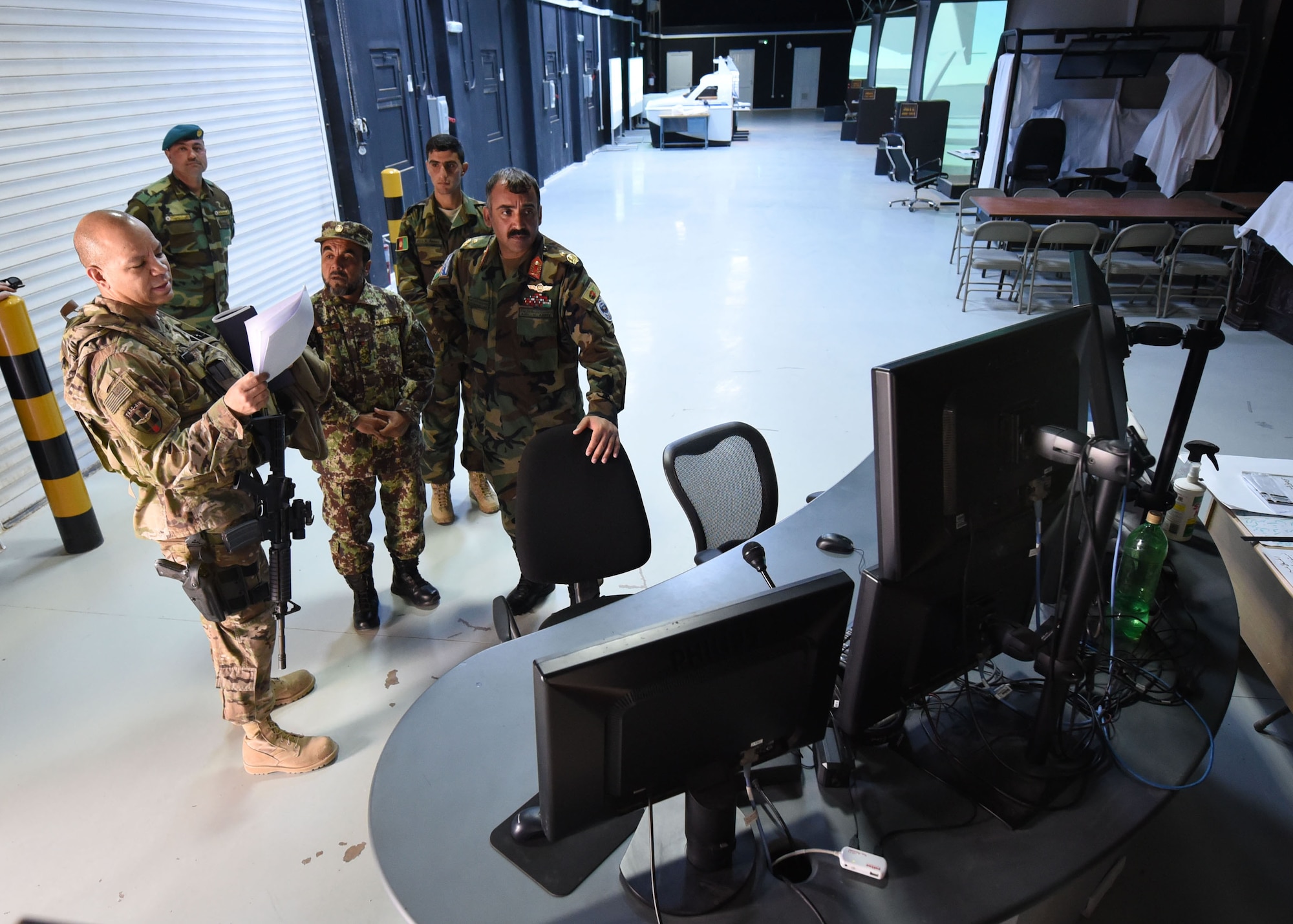 Lt. Col. Jose Lasso, Train, Advise, Assist Command-Air (TAAC-Air) deputy director of logistics, receives a tour of a flight simulator training facility from Afghan Air Force Brig. Gen. Abdul Qudratullah, Shindand Air Wing commander, at Herat, Afghanistan, March 1, 2017. This visit was an opportunity for advisors to have face-to-face interaction with their AAF counterparts. TAAC-Air headquarters is based out of Kabul, Afghanistan. (U.S. Air Force photo by Tech. Sgt. Veronica Pierce) 