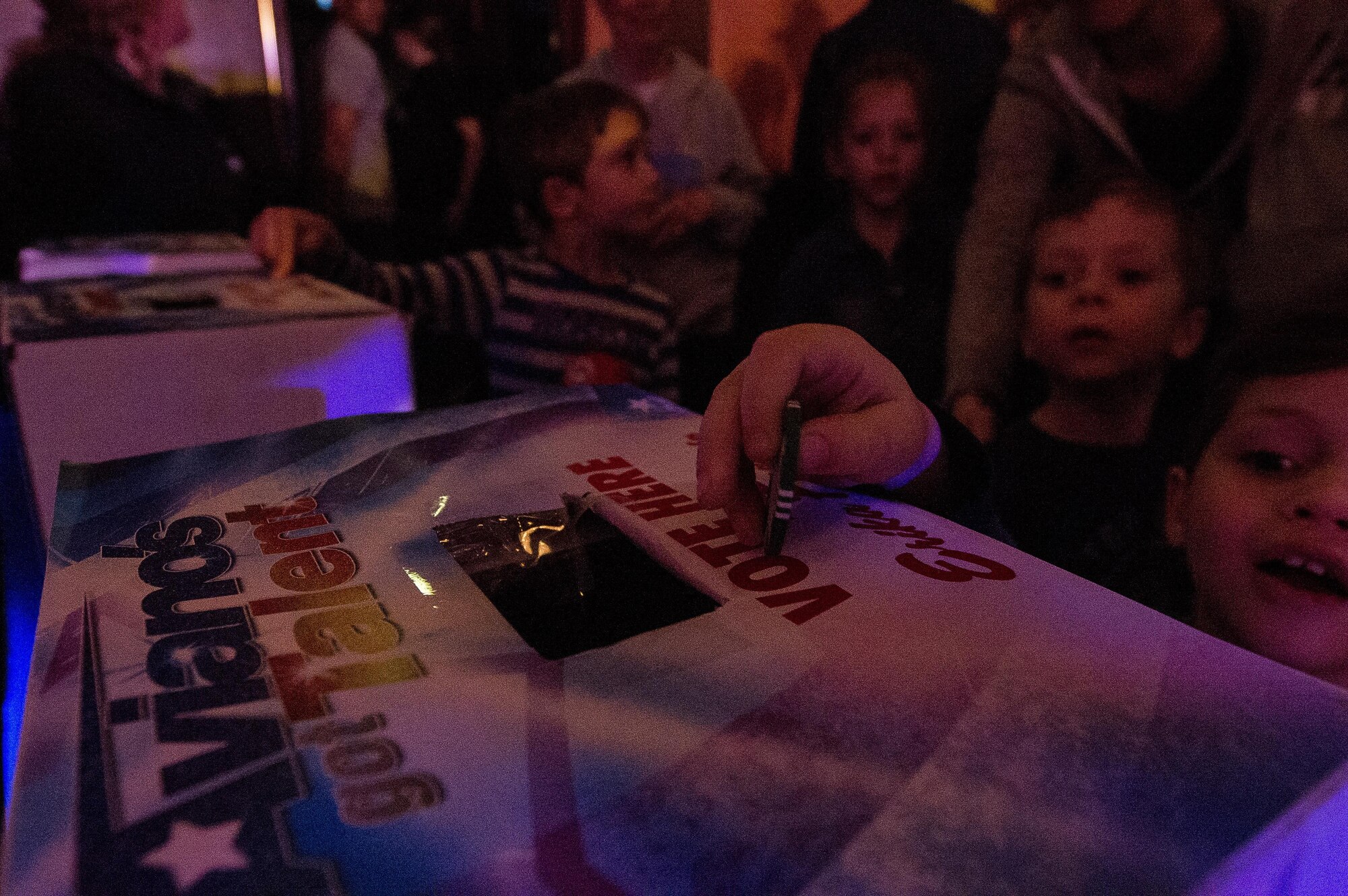 A child casts his vote during the Aviano’s Got Talent finale, March 2, 2017, at Aviano Air Base, Italy. Once the competition cut down to three contestants, the crowds votes helped determine who the winner was. (U.S. Air Force photo by Senior Airman Cory W. Bush)