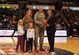 Mr. Joseph D’Antonio, Colonial Athletic Association Commissioner, right, presents Air Force Col. Robert Lyman, Joint Base Charleston commander, center, and his family an autographed basketball during the 2017 CAA Men’s Basketball Championship, March 5, 2017, at the North Charleston Coliseum, South Carolina. The presentation recognized and honored the men and women of Joint Base Charleston and their service to the community and nation. 