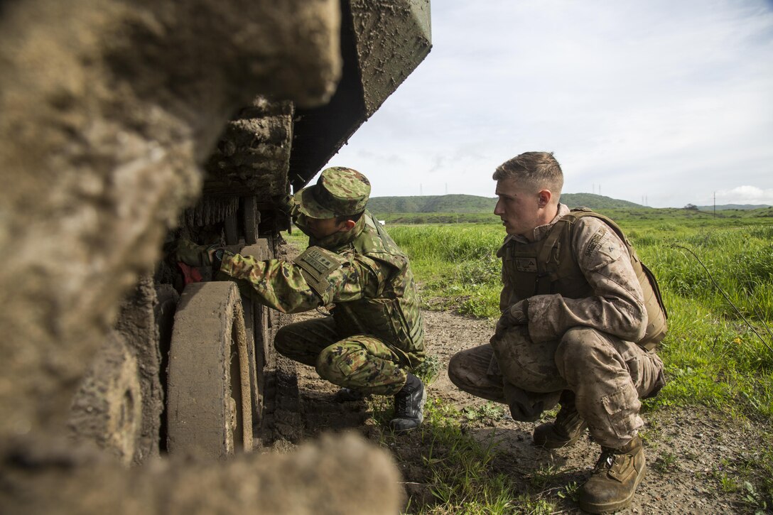 Marine Corps Lance Cpl. Nathaniel Sheffield, an Assault Amphibious Vehicle mechanic conducts a check with a Japanese Ground-Self Defense Force soldier during an AAV land driving training event during Exercise Iron Fist, Marine Corps Base Camp Pendleton, Calif., Feb. 8, 2017. Sheffield is assigned to Headquarters and Support Company, 3rd Assault Amphibian Battalion. Iron Fist is an annual, bilateral training exercise where U.S. and Japanese service members train together and share techniques, tactics and procedures to improve their combined operational capabilities. Marine Corps photo by Lance Cpl. Tyler Byther