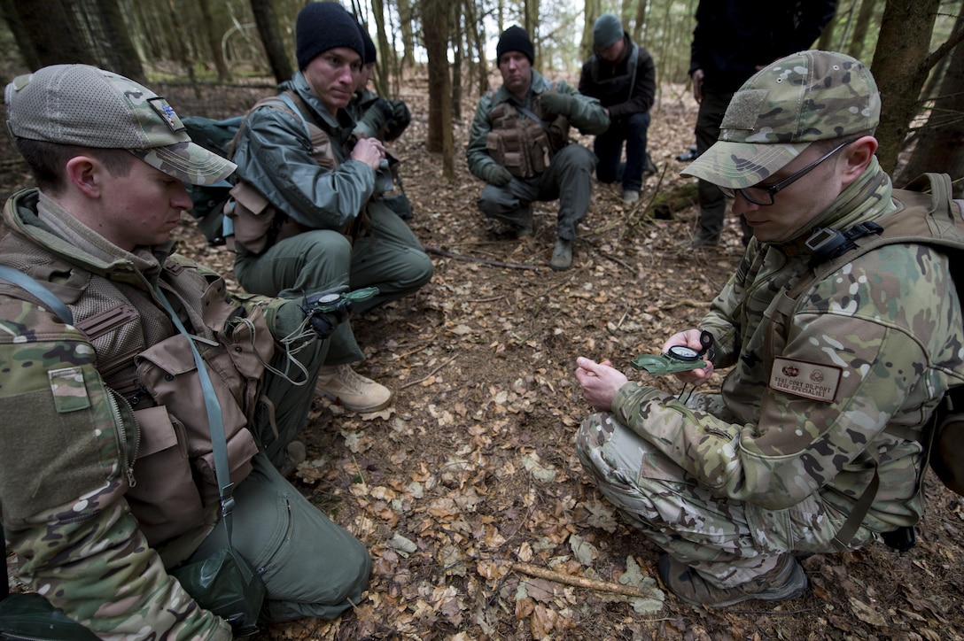 U.S. Air Force Staff Sgt. Corey Dilport, right, 52nd Operations Support Squadron Survival, Evasion, Resistance and Escape specialist, demonstrates compass use during SERE training near Spangdahlem Air Base, Germany, March 3, 2017. The curriculum taught at SEAR trains pilots how to react in the event their aircraft is downed and has three key parts: survival and evasion, resistance and escape, and water survival. (U.S. Air Force photo by Airman 1st Class Preston Cherry)