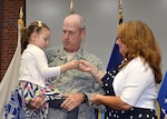Air Force Lt. Col. Michael Allison, chief, Air Force Customer Facing Division, Customer Operations Directorate, Defense Logistics Agency Aviation, gets his new colonel rank pinned on by his wife and their granddaughter during his promotion ceremony Feb. 28, 2017 held on Defense Supply Center, Richmond, Virginia. 