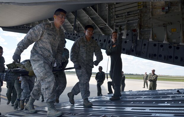 Airman Michael Alvarez, left, and Staff Sgt. Roberto Gonzalez, center, both reservists with the 920th Aeromedical Staging Squadron, load a simulated patient onto a C-17 Globemaster III during the fifth annual MEDBEACH joint medical response exercise March 5, 2017 at Patrick Air Force Base, Florida. The C-17 and an Army National Guard UH-60 Black Hawk were flown in to provide a staging platform for stabilization and transport of battlefield-injured service members. (U.S. Air Force photo/Capt. Leslie Forshaw)