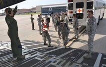 Simulated ambulatory patients are guided up the ramp of a C-17 Globemaster III aircraft March 5, 2017 during the 5th annual MEDBEACH joint medical response exercise at Patrick Air Force Base, Florida. The C-17 was flown in to provide a staging platform for stabilization and transport of battlefield-injured service members. (U.S. Air Force photo/Capt. Leslie Forshaw)