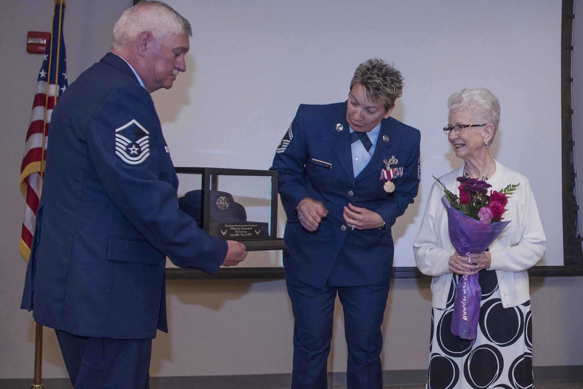 U.S. Air Force Senior Master Sgt. Lisa K. Vanderhoff, 307th Maintenance Squadron structural mechanic, presents her mother with flowers and her mother’s favorite Air Force uniform hat at Barksdale Air Force Base, La., March 4, 2017.  The presentation was made during Vanderhoff’s retirement ceremony. Her mother supported Vanderhoff during her 23 years of service in the Air Force. (U.S. Air Force photo by Technical Sgt. Cody Burt/Released)