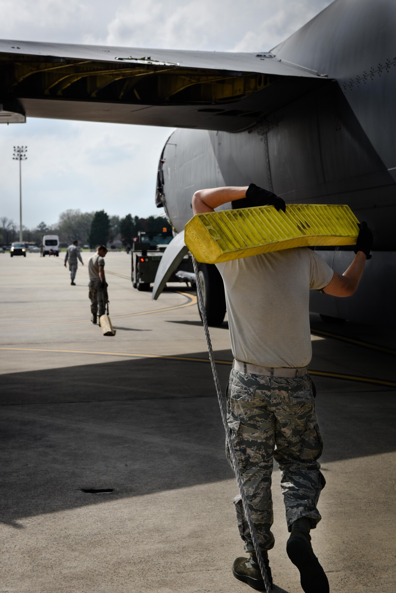An Airmen carries a chock for Aircraft 0049 at Barksdale Air Force Base, La., Feb. 28, 2017. The aircraft will be disassembled then transported to Davis Monthan AFB, as a part source for the flying fleet. (U.S. Air Force photo/Airman 1st Class Stuart Bright)
