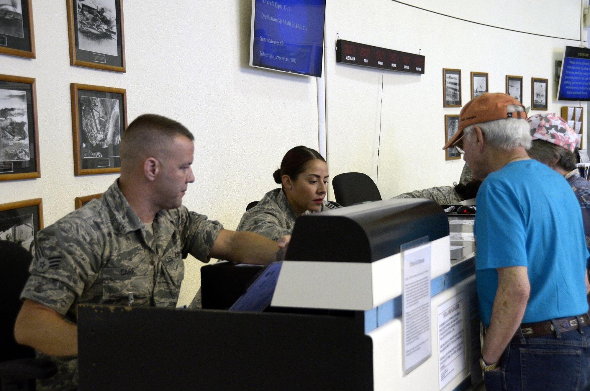 Senior Airman Christian Carr and Staff Sgt. Jennifer Lenz, 87th Aerial Port Squadron, help two passengers check in for their Space Available flight out of Joint Base Pearl Harbor-Hickam, Hawaii, February 16, 2017. During annual training, the Airmen worked the personnel terminal for the 735th Air Mobility Squadron, helping out wherever needed. The 87th APS sent 26 reservists to Hawaii for their annual tour. (U.S. Air Force photo/Staff Sgt. Joel McCullough)