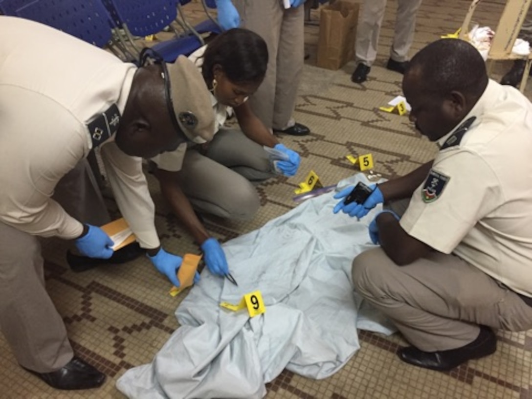 Members of the Burkina Faso National Police attend to a crime scene during the practical exercise portion of the Law Enforcement Investigative Skills Exchange Program, the first-ever Air Force Office of Special Investigations strategic engagement in the West African country, formerly known as Upper Volta. (U.S. Air Force photo/25 EFIS)   