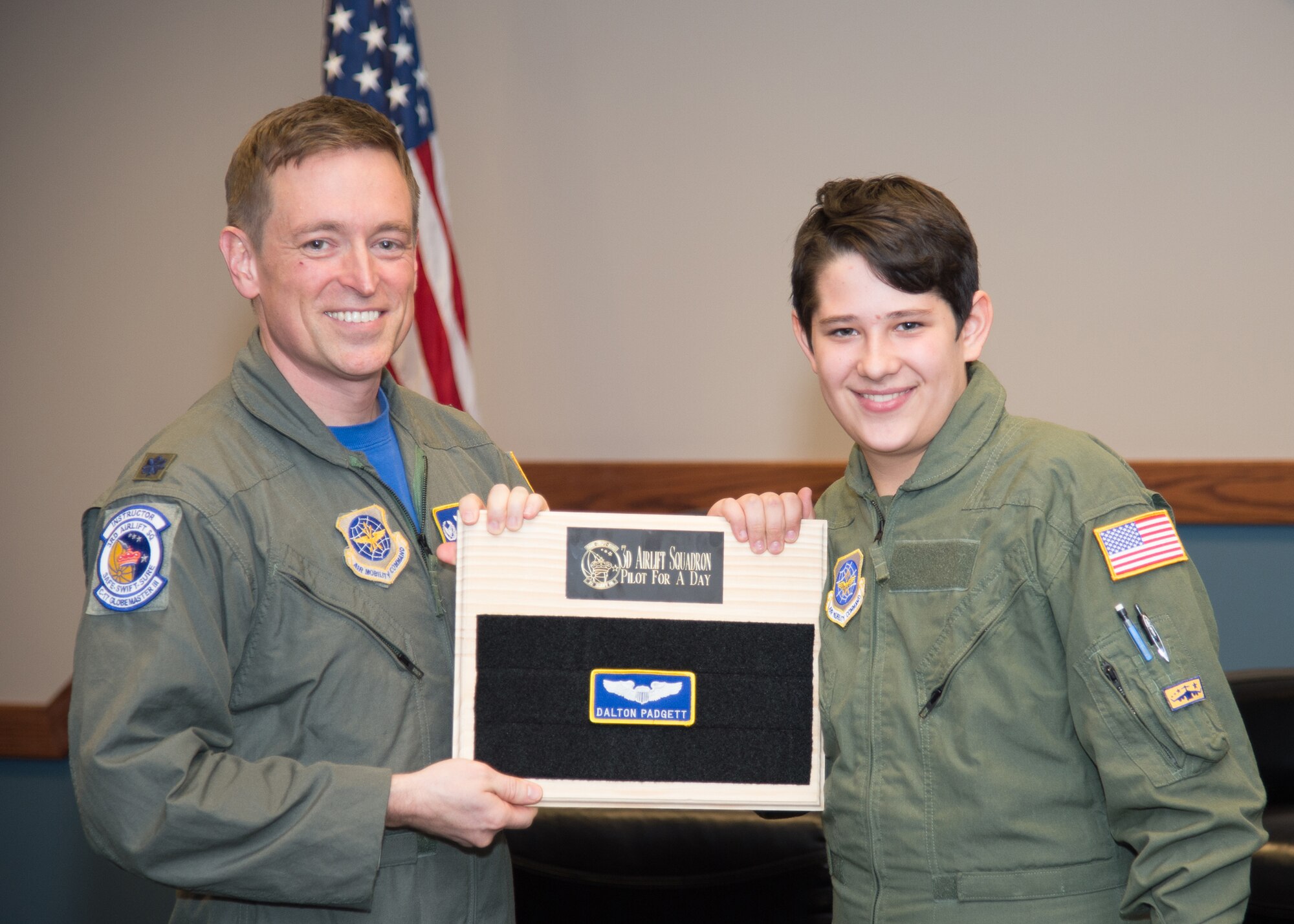 Dalton Padgett and Lt. Col. Mark Radio, 3rd Airlift Squadron commander, conclude the Pilot for a Day tour with a patching ceremony Mar. 3, 2017, at Dover Air Force Base, Del. It is an Air Force tradition for pilots to leave their name patch at the squadron when their tour of duty comes to an end. (U.S. Air Force photo by Mauricio Campino)