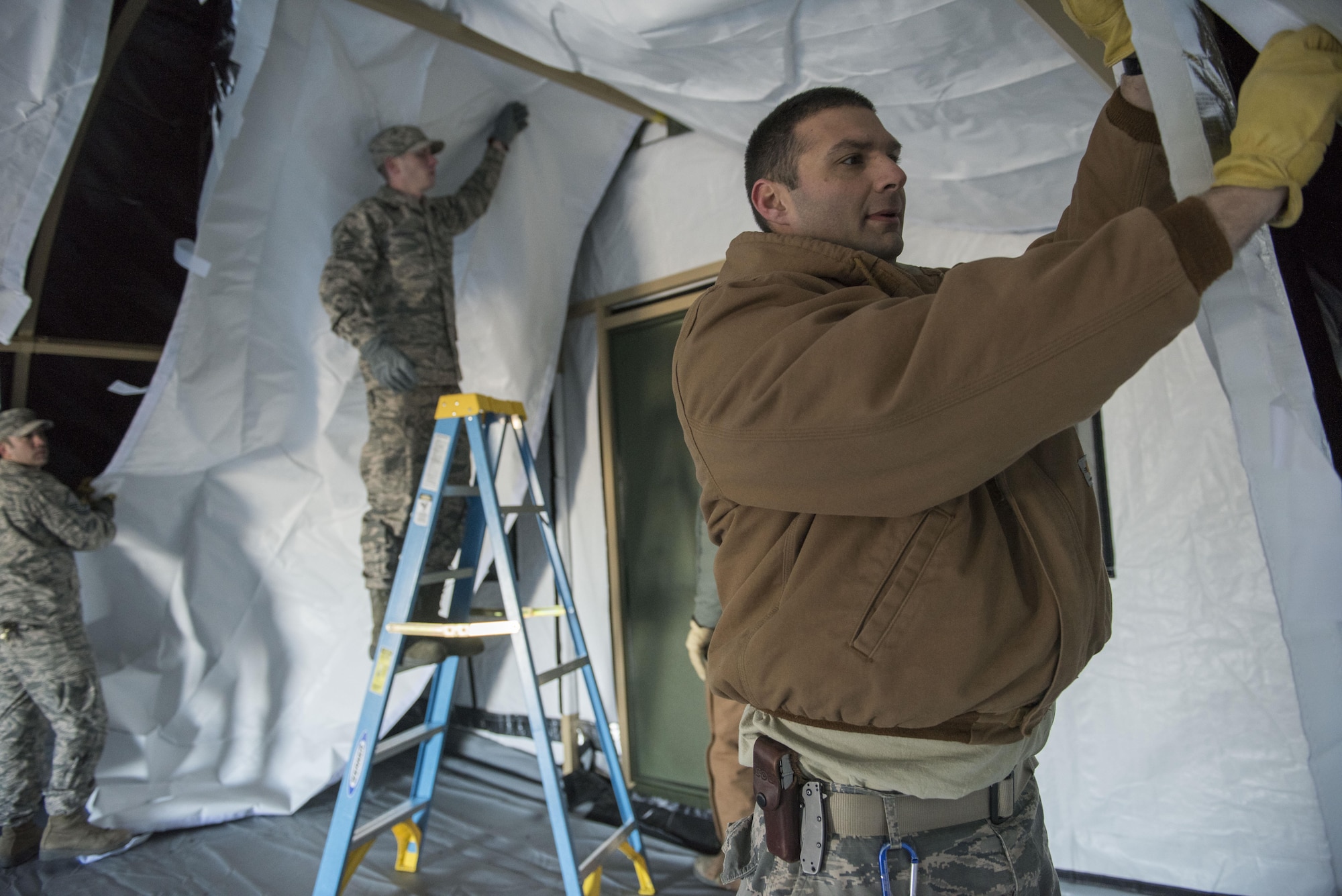 Members of the 366th Civil Engineering Squadron finish applying the inner lining of a tent Mar. 2, 2017, at Mountain Home Air Force Base, Idaho. Several tents were erected throughout the morning as part of a readiness exercise. (U.S. Air Force photo by Senior Airman Connor Marth/Released)