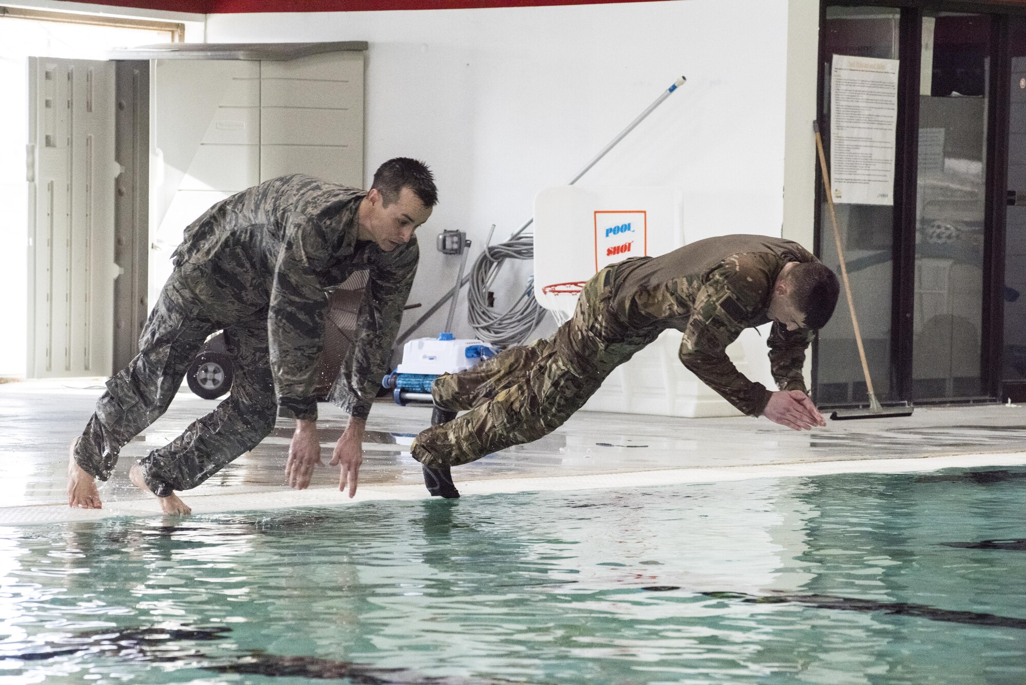 1st Lt. Cory Bobo, 67th Aerial Port Squadron ramp services flight commander (left), and Capt. Sterling Broadhead, 419th Fighter Wing executive officer, dive into the pool March 4, 2017 at Hill Air Force Base, Utah, in preparation for tryouts for the Interallied Confederation of Reserve Officers Military Competition to take place August 2017 in Prague, Czech Republic. (U.S. Air Force photo/Senior Airman Justin Fuchs)