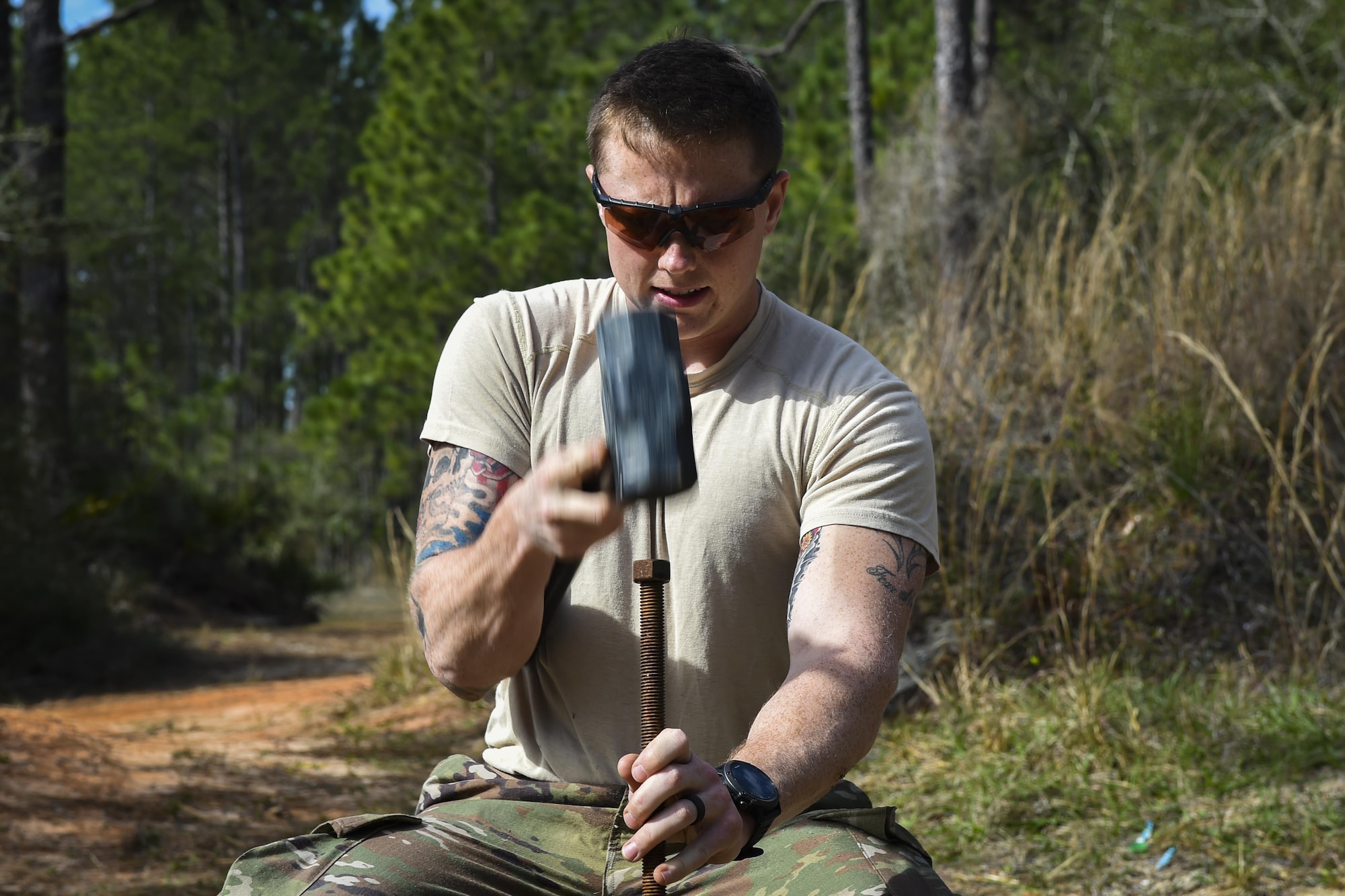 Airman 1st Class Lawrence Gress, an explosive ordinance disposal journeyman with the 1st Special Operations Civil Engineer Squadron, hammers a steel rebar rod into the ground during EOD tool training at Hurlburt Field, Fla., Mar. 6, 2017. The steel rebar rod is used to fasten 550 paracord to a MK1 rocket wrench that removes fuses from projectiles. (U.S. Air Force photo by Airman 1st Class Joseph Pick)