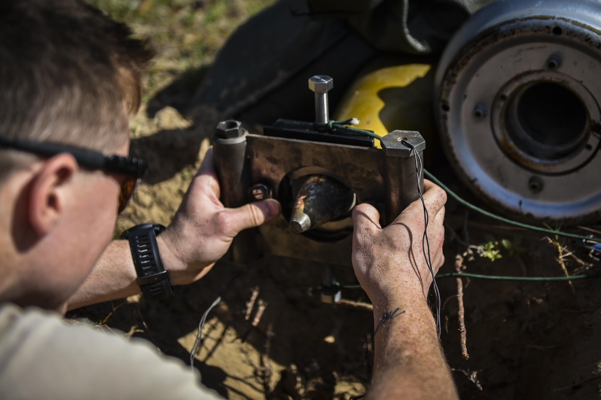 Airman 1st Class Lawrence Gress, an explosive ordinance disposal journeyman with the 1st Special Operations Civil Engineer Squadron, secures a MK1 rocket wrench on the fuse of a projectile during EOD tool training at Hurlburt Field, Fla., Mar. 6, 2017. If the rocket wrench is not straight, it may not properly remove the fuse and could cause damage to the tool. (U.S. Air Force photo by Airman 1st Class Joseph Pick)