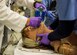 Master Sgt. Barbara Lay, 60th Medical Group, and Capt. Andrew Morton, 82nd Medical Operations Squadron, stabilize the airway of a Athena, the first-ever simulator of its type, to be utilized in the Department of Defense, in St. Louis, Missouri.  The simulator has female features and offers advanced ventilation technology, serving as a vital piece to providing the best medical training possible for students completing the program. (U.S. Air Force Photo / SSgt Jodi Martinez)