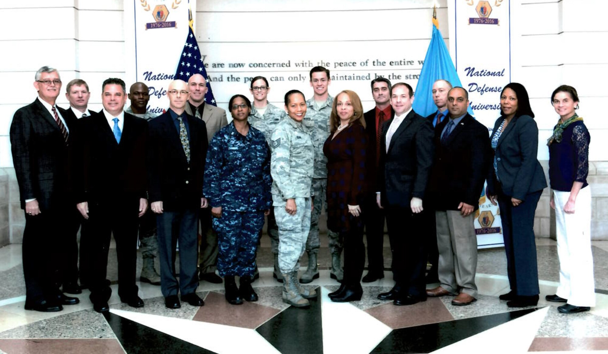 Airman 1st Class Lindsey Plotner and Airman 1st Class Joseph Mousch, center, back row, are pictured with the staff and seminar leaders for the Reserve Component National Security Course at the National Defense University. Plotner and Mousch, provided administrative support for the course, an assignment much different from their primary duties as aircraft maintenance specialists.