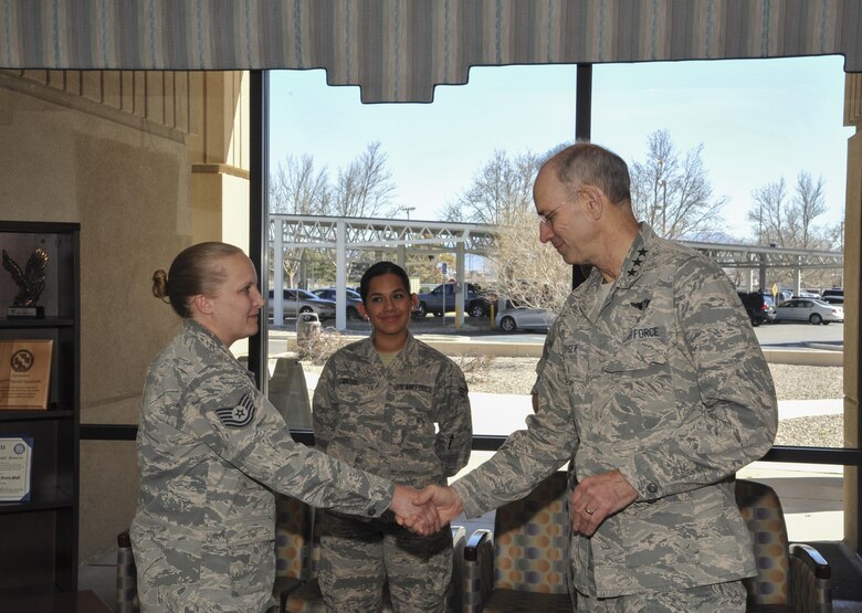 Lt. Gen. Mark Ediger, Surgeon General of the Air Force, coins Tech. Sgt. Tanya Cole, NCOIC of the Dental Squadron during a visit to Kirtland Air Force Base March 2. Ediger recognized several members of the MDG team for being outstanding professionals in their career fields. 