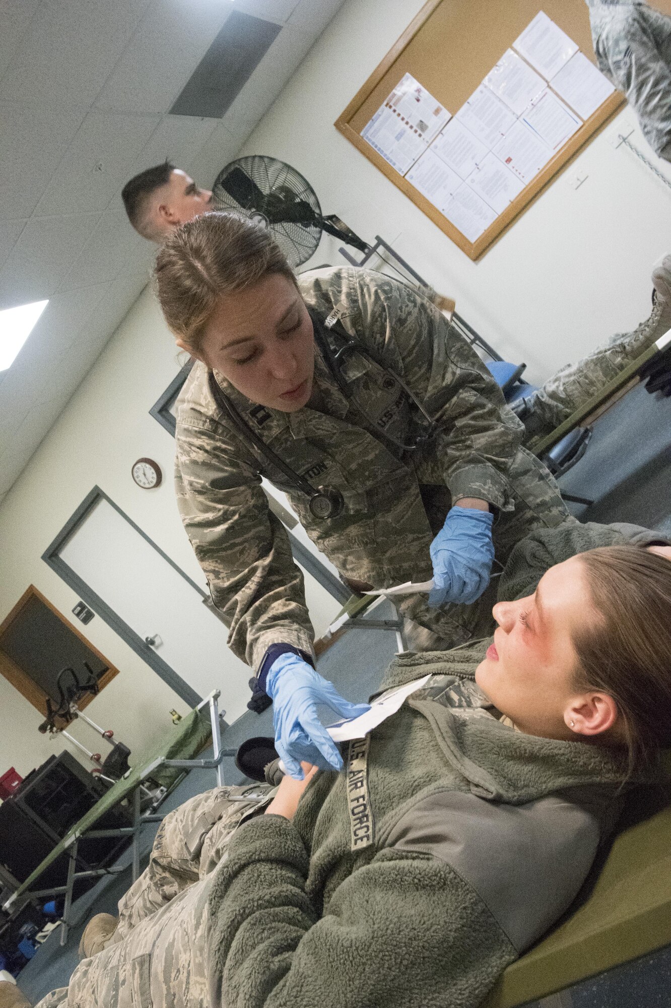 PETERSON AIR FORCE BASE, Colo. – Capt. Emma Pinkerton, Cheyenne Mountain Air Force Station Medical Aid Station nurse, applies simulated first aid to a mock victim during a mass casualty exercise during button-up contingency triage training at the Cheyenne Mountain AFS, Colo., March 3, 2017. The training is designed to stress Cheyenne Mountain AFS medical responders, who are on call from Peterson Air Force Base Medical Clinic, to simulate the stress that a future buttoned up mass casualty event could cause. (U.S. Air Force photo by Steve Kotecki)