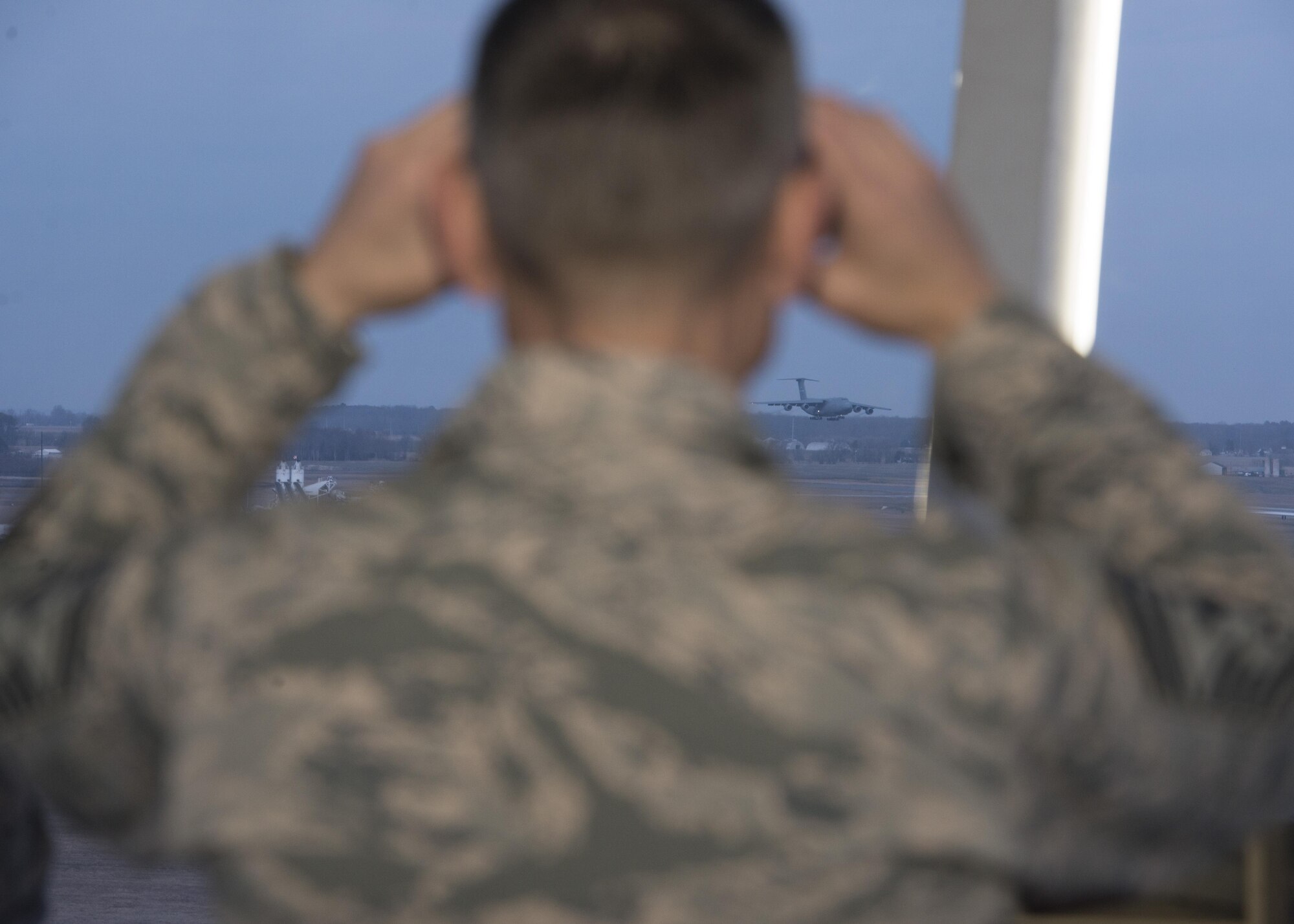 Chief Master Sgt. Todd Petzel, 18th Air Force command chief, uses binoculars to watch a C-5M Super Galaxy land Feb. 28, 2017, at Dover Air Force Base, Delaware. Dover AFB is one of two C-5M bases that report to 18th AF. Dover’s C-5Ms and C-17 Globemaster III aircraft delivered more than 127 million pounds of cargo and 11,000 passengers last year alone. (U.S. Air Force photo by Senior Airman Zachary Cacicia)