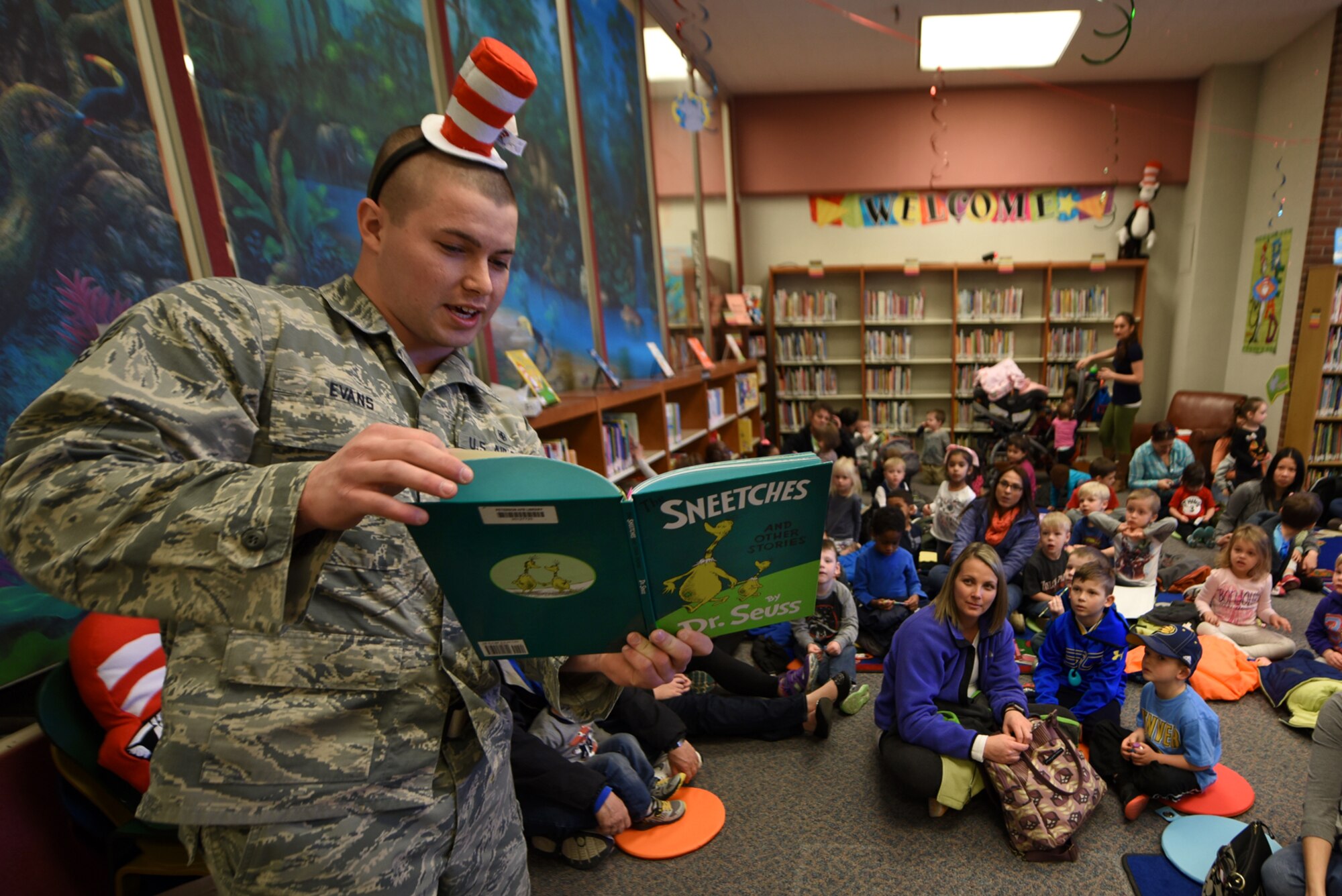 PETERSON AIR FORCE BASE, Colo. – Senior Airman Jace Evans, 21st Medical Group dental lab technician, reads a Dr. Seuss story to children in the library at Peterson Air Force Base, Colo., March 2, 2017. Evans and the other readers encouraged participation from the children. (U.S. Air Force photo by Airman 1st Class Dennis Hoffman)