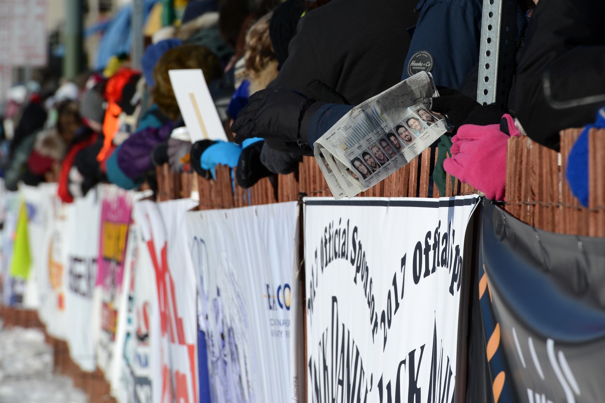 A crowd member follows the ceremonial start to the 45th annual Iditarod Trail Sled Dog Race with a newspaper showing all the participants in Anchorage, Alaska, March 4, 2017. More than 1,150 dogs pulled 72 mushers for the day’s 11-mile run to Campbell Airstrip. 