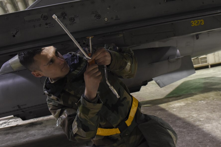 U.S. Air Force Airman 1st Class Reagan Bounner, 80th Aircraft Maintenance Unit weapons load crew member, tightens a mount on an F-16 Fighting Falcon during exercise Beverly Pack 17-2, a no-notice training exercise at Kunsan Air Base, Republic of Korea, March 7,  2017. This exercise was conducted to enhance the readiness and proficiency of Airmen while in a simulated contingency operation. (U.S. Air Force photo by Senior Airman Michael Hunsaker/Released)