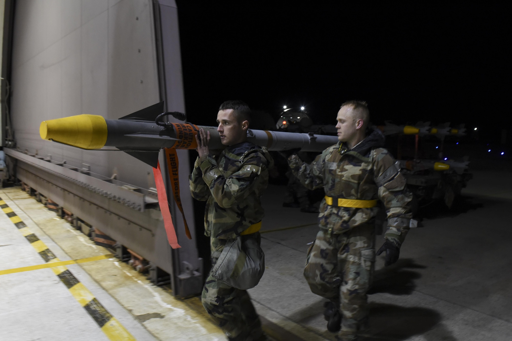 U.S. Air Force Airman 1st Class Reagan Bounner and Staff Sgt. Benjamin Callesen, 80th Aircraft Maintenance Unit weapons load crew members, transport an Aim-9X Sidewinder air-to-air missile to upload on an F-16 Fighting Falcon during exercise Beverly Pack 17-2, a no-notice training exercise at Kunsan Air Base, Republic of Korea, March 7, 2017. Airmen here are responsible for employing airpower to deter aggression, preserve the Armistice and defend the Republic of Korea. (U.S. Air Force photo by Senior Airman Michael Hunsaker/Released)