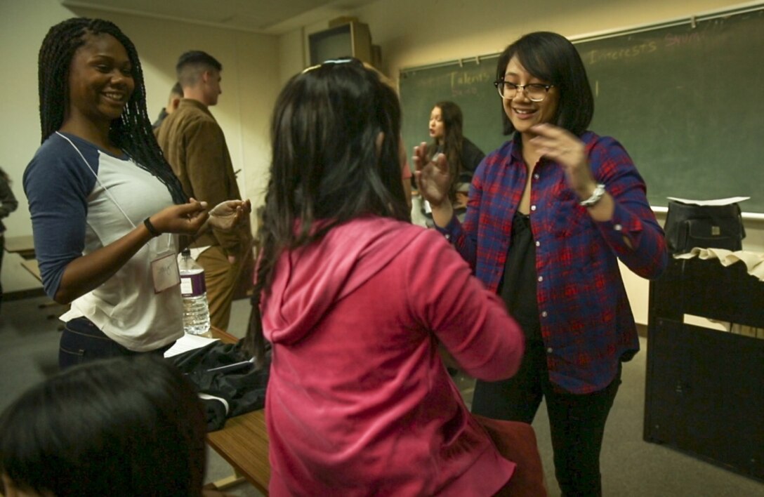 Lance Cpl. Shay Rudderwilson (left) and Lance Cpl. Josabel Gaspar (right), both intelligence specialists with 3rd Intelligence Battalion, III Marine Expeditionary Force Headquarters Group, play with an Okinawan child during the Kin-Hansen Friendship English Class at the Kin Town Central Community Center, the largest community center in Kin Town, Okinawa, Japan, Feb. 28, 2017. The Kin-Hansen English Class is a weekly English conversation class hosted to strengthen the bond between local nationals and service members and to provide the opportunity to talk with one another. Rudderwilson is a native of Stratford, Connecticut; Gaspar is from Mira Mesa, California. (U.S. Marine Corps photo by Lance Cpl. Andy Martinez) 
