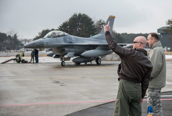 U.S. Air Force Col. R. Scott Jobe, 35th Fighter Wing commander, displays the 14th Fighter Squadron's (FS) cheer “wood” as a pilot taxis by at Misawa Air Base, Japan, March 4, 2017. The 14th FS recently returned from exercise COPE NORTH 17 at Andersen Air Force Base, Guam. It included 22 total flying units and more than 1,700 personnel from three countries. The purpose was to grow strong, interoperable relationships within the Indo-Asia-Pacific region through integration of airborne and land-based command and control assets. (U.S. Air Force photo by Senior Airman Brittany A. Chase)