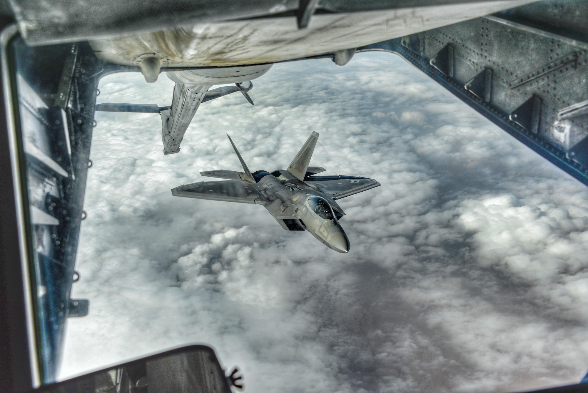 U.S. Air Force Lt. Col. August Pfluger, 380th Expeditionary Operations Support Sq. commander and F-22 Raptor pilot, maneuvers a Raptor into position to receive fuel during an air refueling over Syria, March 3, 2017.  During the refueling Pfluger re-enlisted Staff Sgt. Rebecca Rains who was in a KC-10 Extender, next to the boom operator, while reciting the oath of enlistment over headset.  “I really like the AF and I’m very passionate about my job,” Rains said.  “People are motivated in different ways and being out here supporting real-world operations and seeing the impact that my job provides for the AOR internally motivates me. I feel lucky to have had this opportunity.”  