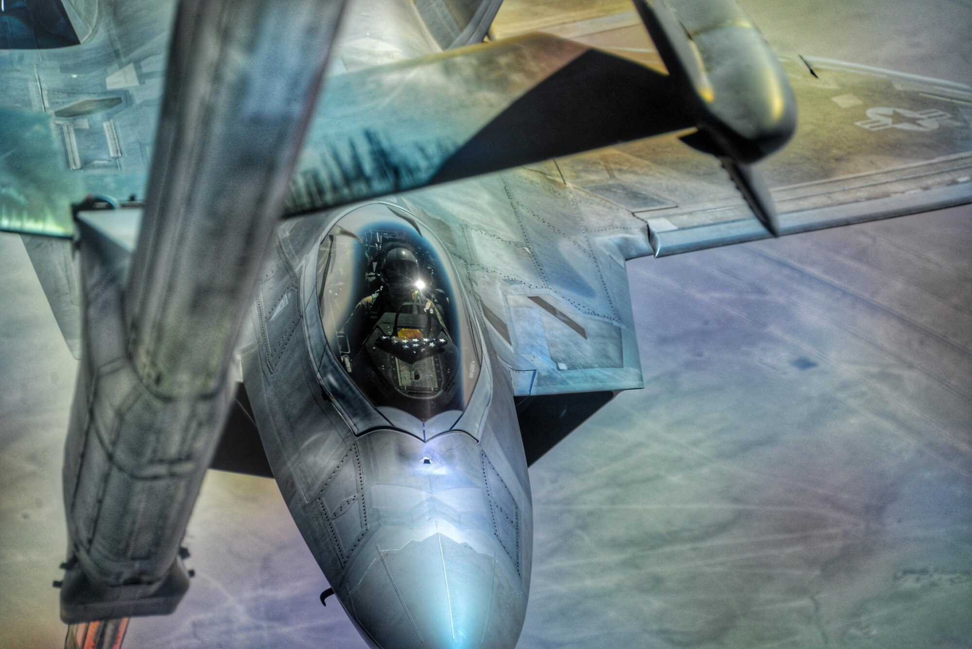 U.S. Air Force Lt. Col. August Pfluger, 380th Expeditionary Operations Support Sq. commander and F-22 Raptor pilot, maneuvers an F-22 into position to receive fuel during an air refueling over Syria, March 3, 2017.  During the refueling Pfluger re-enlisted Staff Sgt. Rebecca Rains who was in a KC-10 Extender, next to the boom operator, while reciting the oath of enlistment over headset.  “This was the coolest thing I’ve done [since joining],” Rains said.  “So I get on the headset and I’m talking to him and he shared with me some background about his mission prior to coming up for fuel.  He then said ‘You ready to do this?’ and I said ‘yep let’s go.’” 