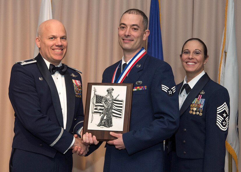 Col. Roman L. Hund, installation commander, presents the Airman of the Year award to Senior Airman Kenneth T. McGuire, a member of the 66th Air Base Group, during the Team Hanscom Annual Awards Banquet at the Minuteman Commons March 3, Command Chief Master Sgt. Patricia L. Hickey assisted with presenting the award. The awards program, the first of its kind held at Hanscom, recognizes Air Force officers, enlisted, federal civilian and non-appropriated fund employees, as well as teams. (U.S. Air Force photo by Jerry Saslav)