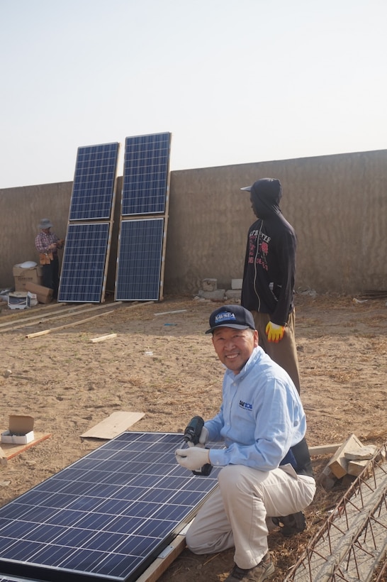 Peter Cho, an electrical engineer in the marine and aviation division at Naval Surface Warfare Center, Carderock Division, in West Bethesda, Md., prepares a solar panel to bring light to a community in the rural West African city of Mbour, Senegal. Courtesy photo