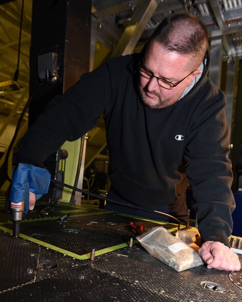 Bob Berg, M1 Support Services aircraft mechanic, uses a rivet gun to secure rivets in place as he installs new floor paneling on a UH-1N Huey helicopter during a scheduled phase maintenance inspection on the aircraft March 6, 2017, at Malmstrom Air Force Base, Mont.  The phase inspection period usually lasts 4 to 6 weeks and routinely occurs after 400 flight hours.  Berg, along with three other mechanics maintain, upgrade and inspect aircraft to ensure the aircrafts are flight ready.  (U.S. Air Force photo/Jason Heavner)