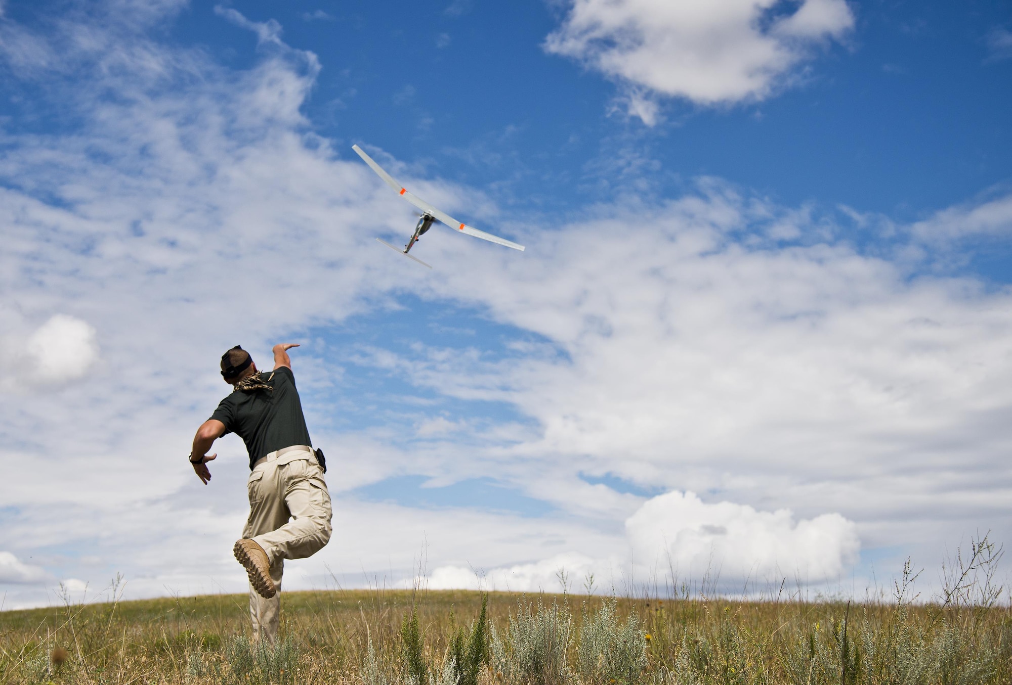 Staff Sgt. Leland Hastings, of the 919th Special Operations Security Forces Squadron, launches a Raven-B, a 4-by-4 foot unmanned aerial system, into the skies above Camp Guernsey, Wyo., Aug. 4, 2015. The 919th SOSFS brought the UAS to demonstrate its capabilities to other security forces units involved in a large field training exercise at the camp. The Raven-B has the ability to take photos, video in day or night, and even designate locations via an IR laser.  It also provides coordinates, magnetic azimuths, and linear distances creating a birds-eye view to topographical map. (U.S. Air Force photo/Tech. Sgt. Sam King)