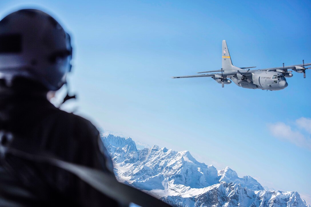 Air Force Tech. Sgt. Liz Slagle watches another C-130 Hercules aircraft while flying in a formation over Denali National Park, Alaska, March 4, 2017. Slagle is a loadmaster assigned to the Alaska Air National Guard's 144th Airlift Squadron. Air National Guard photo by Staff Sgt. Edward Eagerton