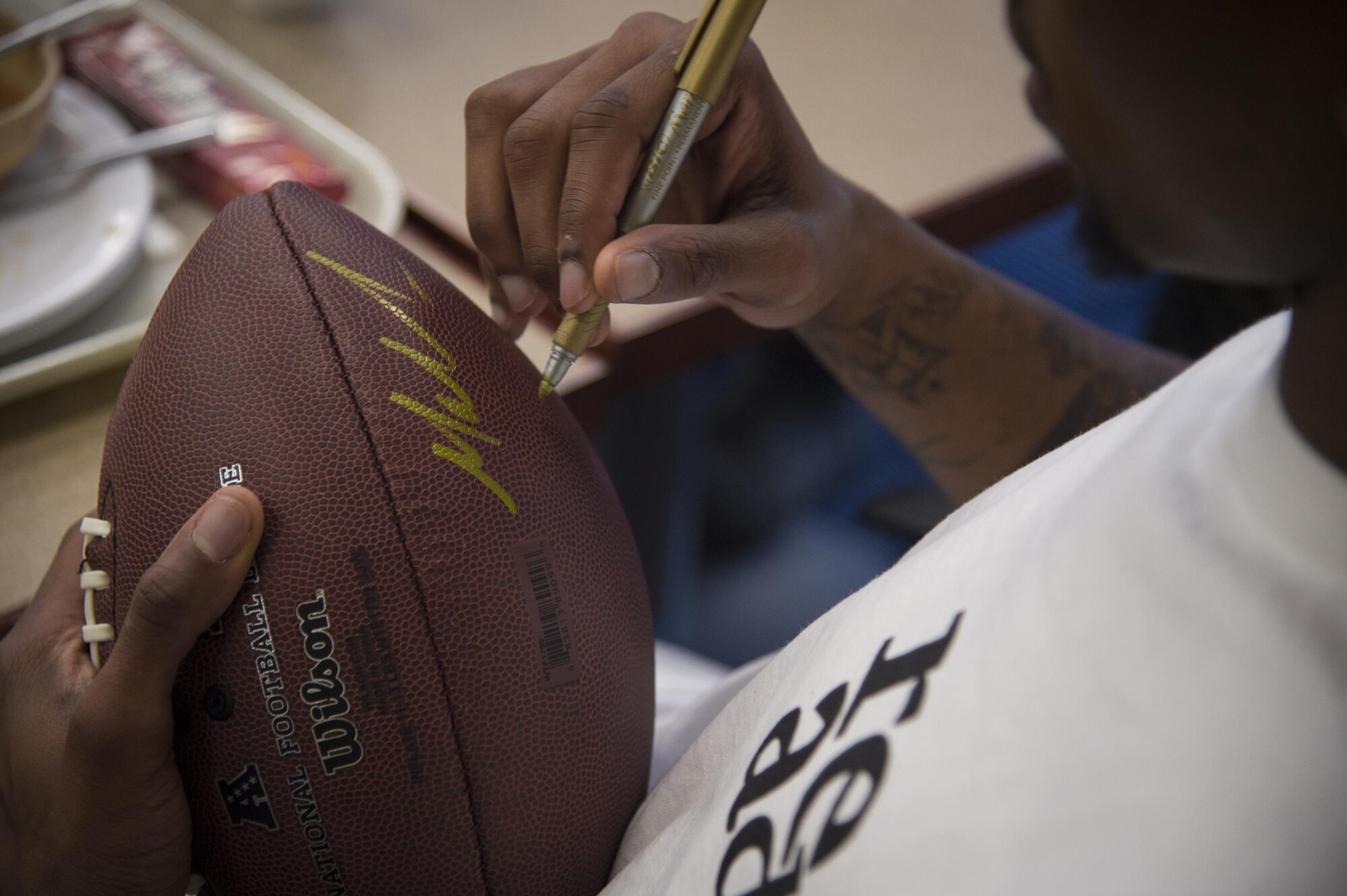 Malcolm Mitchell, New England Patriots’ wide receiver and Super Bowl LI Champion, signs a football during a visit March 7, 2017, at Moody Air Force Base, Ga. Mitchell, a Valdosta native, got a glimpse of a typical day in the life of Moody Airmen. Mitchell also spent time with Airmen and signed autographs for local Patriots’ fans during his visit. (U.S. Air Force photo by Senior Airman Ceaira Young)
