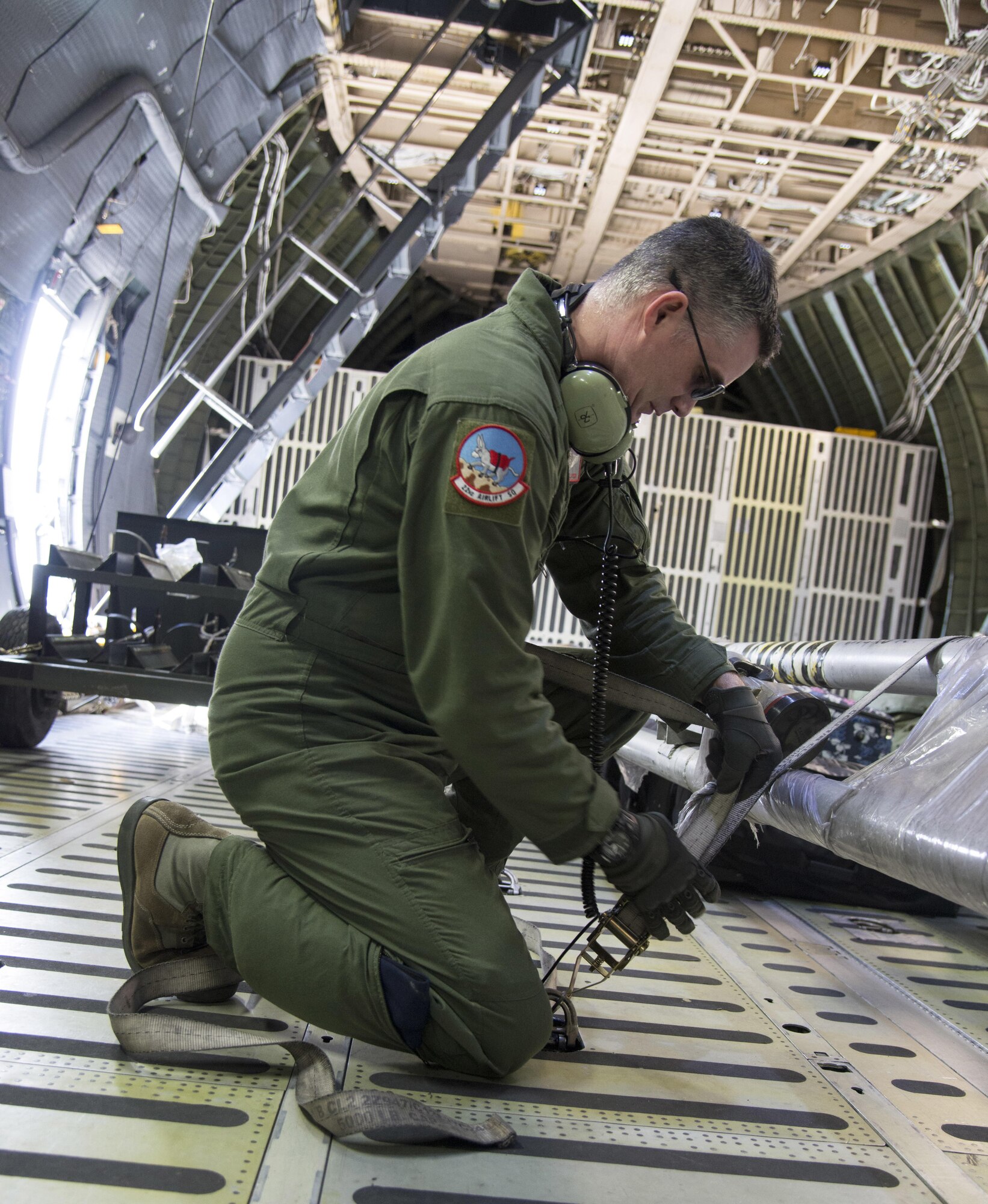 Staff Sgt. Matthew Larson, 22nd Airlift Squadron, secures cargo on a C-5M Super Galaxy prior to a flight to Yokota Air Base Japan, March 4, 2017. Larson and his team of loadmasters secured approximately 70,000 pounds of cargo along with seven passengers flying Space-Avaliable travel. (U.S. Air Force photo/Staff Sgt. Nicole Leidholm)
