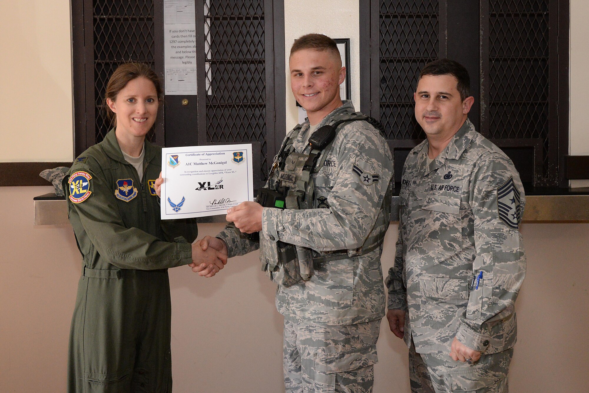 Airman 1st Class Matthew McGonigal, 47th Security Forces Squadron patrolman (center), accepts the “XLer of the Week” award from Col. Michelle Pryor, 47th Flying Training Wing vice commander (left), and Chief Master Sgt. George Richey, 47th FTW command chief (right), on Laughlin Air Force Base, Texas, March 2, 2017. The XLer is a weekly award chosen by wing leadership and is presented to those who consistently make outstanding contributions to their unit and Laughlin. (U.S. Air Force photo/Airman 1st Class Daniel Hambor)