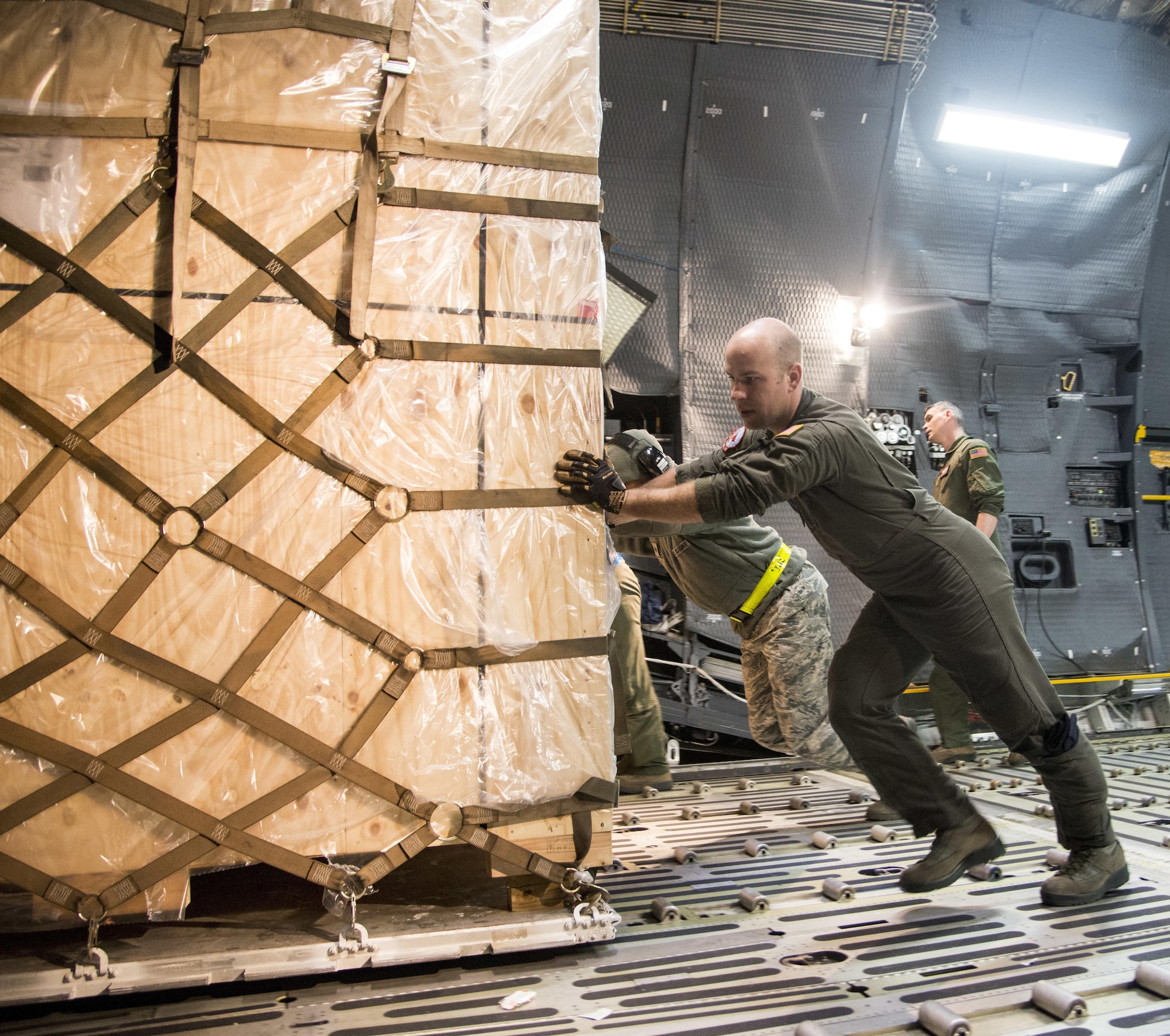 Senior Airman Elias Wilson, 22nd Airlift Squadron, offloads cargo with Airmen from the 730th Air Mobility Squadron after arriving to Yokota Air Base, Japan, March 5, 2017. The team worked together to offload nearly 50,000 pounds of various cargo. (U.S. Air Force photo/Staff Sgt. Nicole Leidholm)