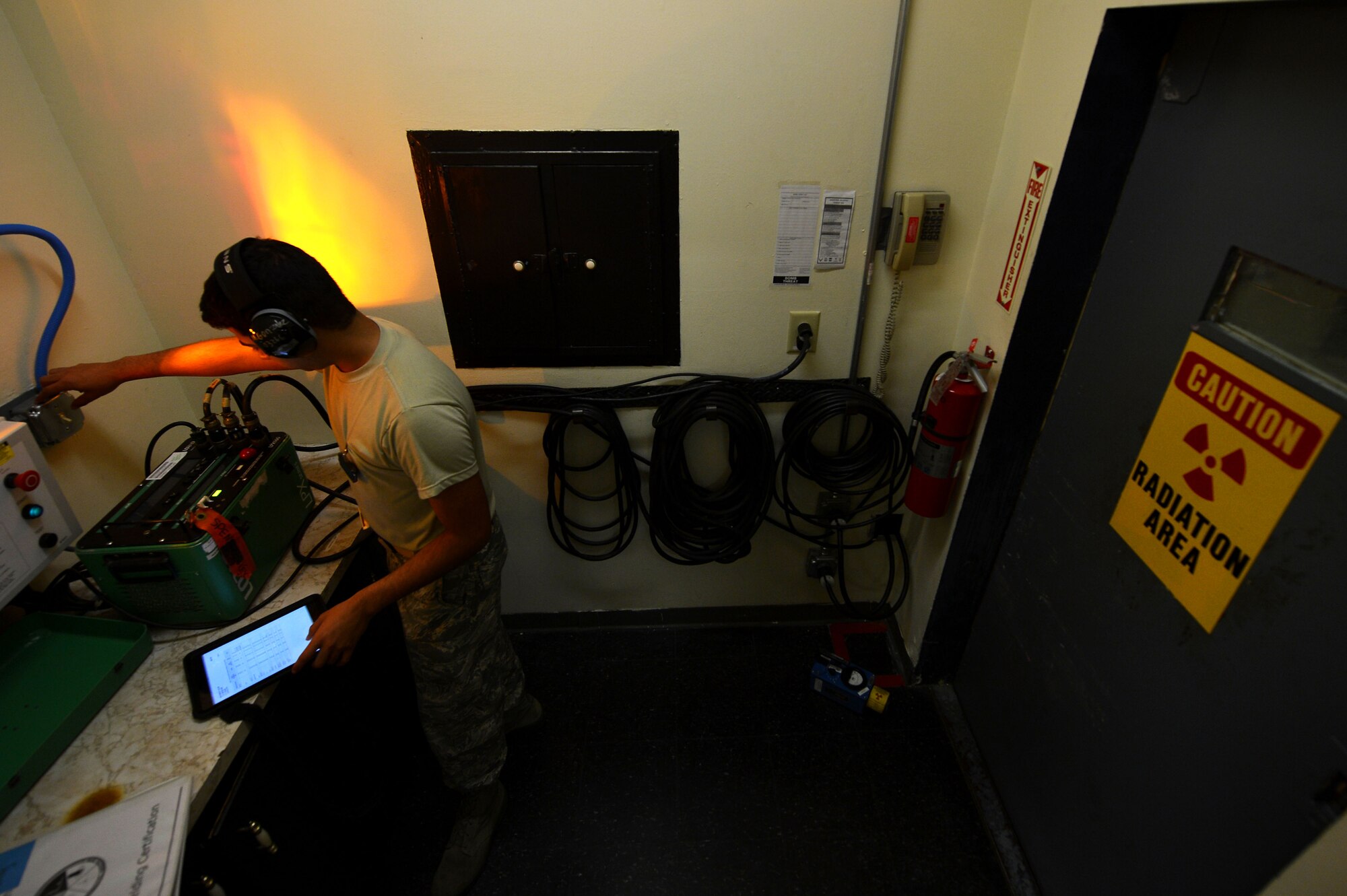 U.S. Air Force Airman 1st Class Marco Gonzalez, 20th Equipment Maintenance Squadron non-destructive inspection apprentice, activates an x-ray testing siren outside the x-ray vault at Shaw Air Force Base, S.C., March 7, 2017. The siren alerts the facility and any outside service members that radioactive waves are being fired by emitting a blinking red and yellow light. (U.S. Air Force photo by Airman 1st Class Christopher Maldonado)
